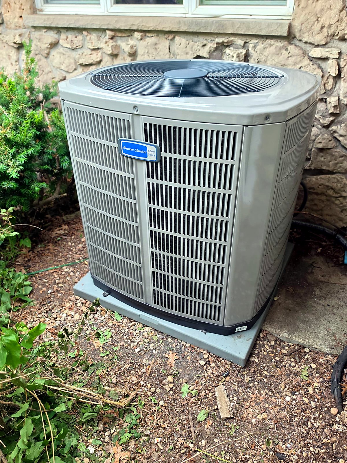 American Standard air conditioner installed beside a stone home in Wisconsin